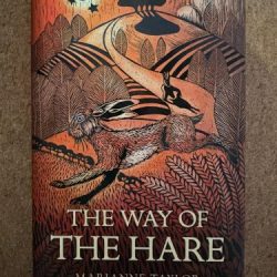 Lino cut image of hares running through landscape in shades of autumn and black