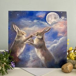 a painted image of 2 hares boxing with a full moon and clouds behind